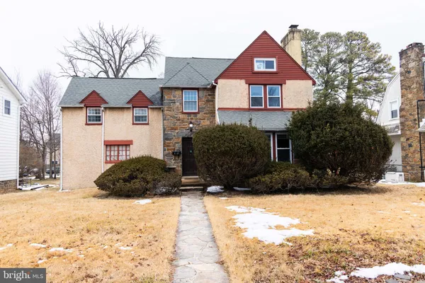 a front view of a house with a yard covered in snow
