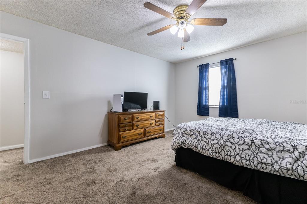6519 West Newberry Road, Unit 805 Gainesville, FL 32605 - Photo 11 of 39 a bedroom with a bed and a flat screen tv