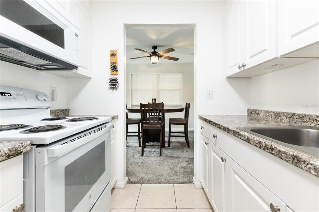 6519 West Newberry Road, Unit 805 Gainesville, FL 32605 - Photo 14 of 39 a kitchen with stainless steel appliances granite countertop a stove a sink and a refrigerator