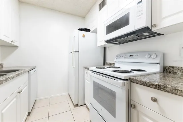a kitchen with granite countertop cabinets a stove and a sink