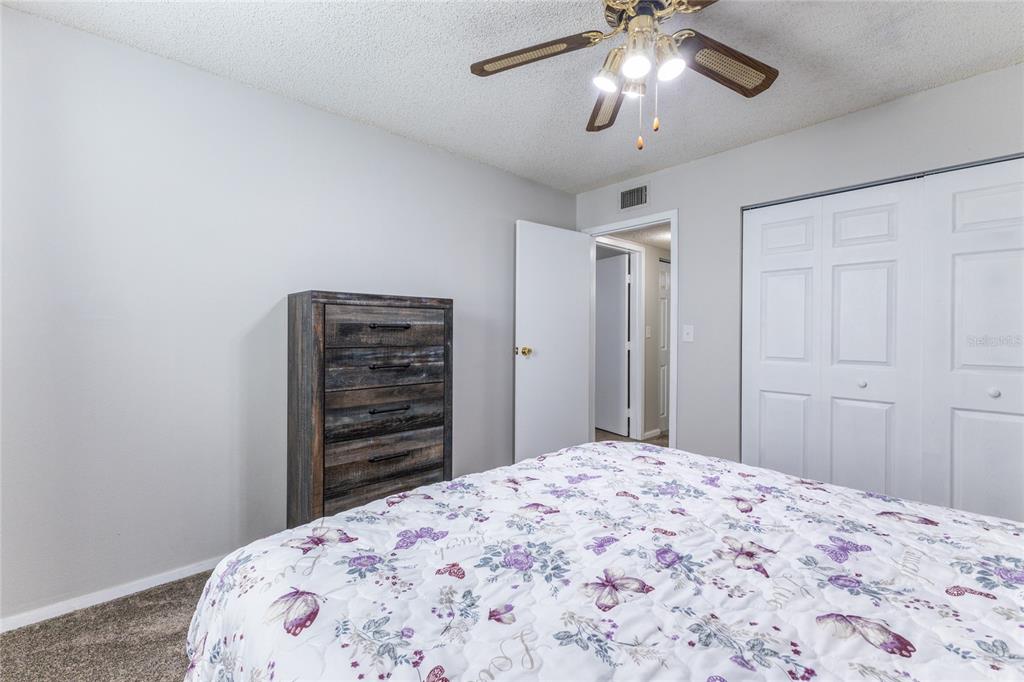 6519 West Newberry Road, Unit 805 Gainesville, FL 32605 - Photo 21 of 39 a bedroom with a bed and a chandelier