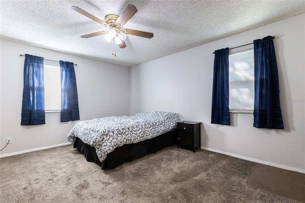 6519 West Newberry Road, Unit 805 Gainesville, FL 32605 - Photo 33 of 39 a bedroom with a bed and a flat tv screen on dresser