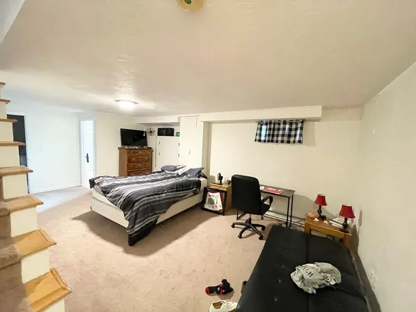 a bedroom with a bed gym equipment and view of living room