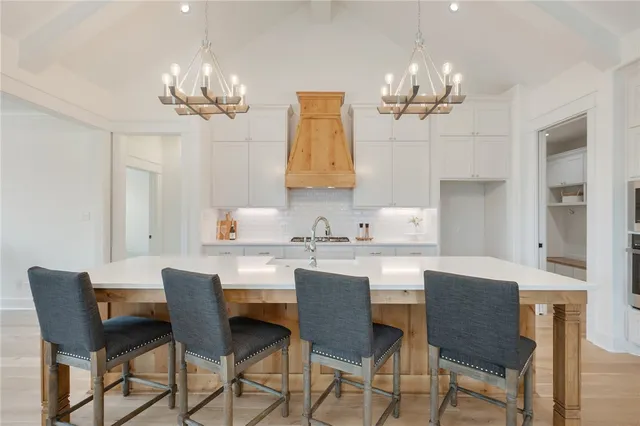 a kitchen with kitchen island stainless steel appliances a sink a counter space and a window