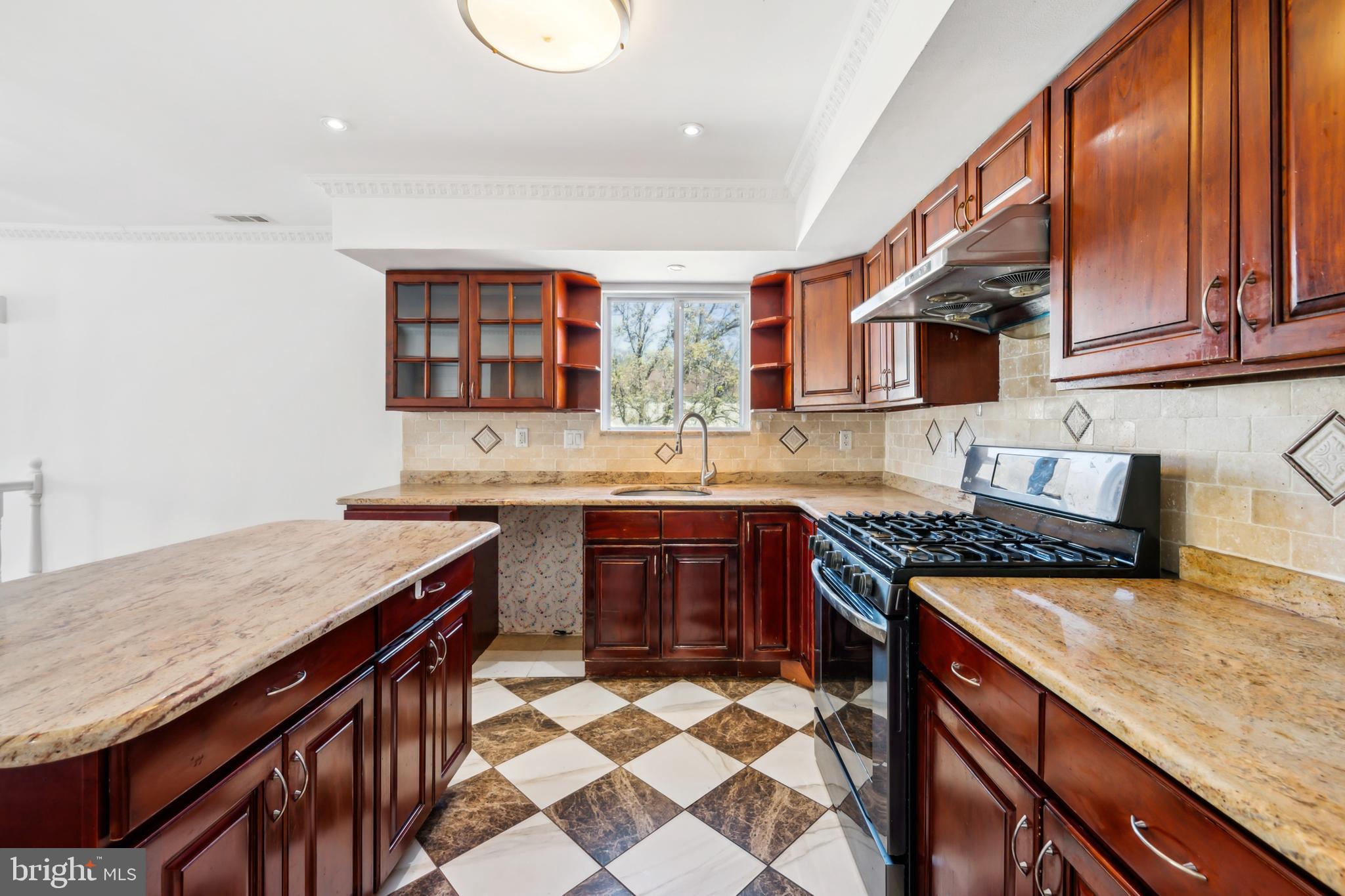 1986 Greentree Road Cherry Hill, NJ 08003 - Photo 8 of 25 a kitchen with a stove a sink a microwave and wooden cabinets