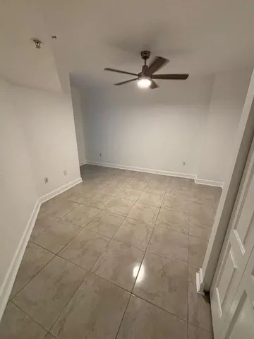 an empty room with a ceiling fan and bathroom