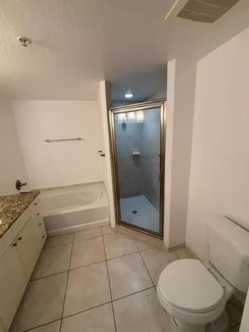 a bathroom with a granite countertop sink a toilet and shower