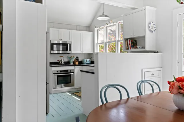 a kitchen with stainless steel appliances granite countertop a stove a sink a refrigerator and white cabinets