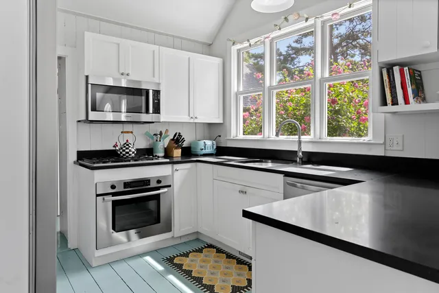 a kitchen with stainless steel appliances a stove a microwave and a sink