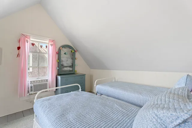 a bedroom with a bed dresser and window