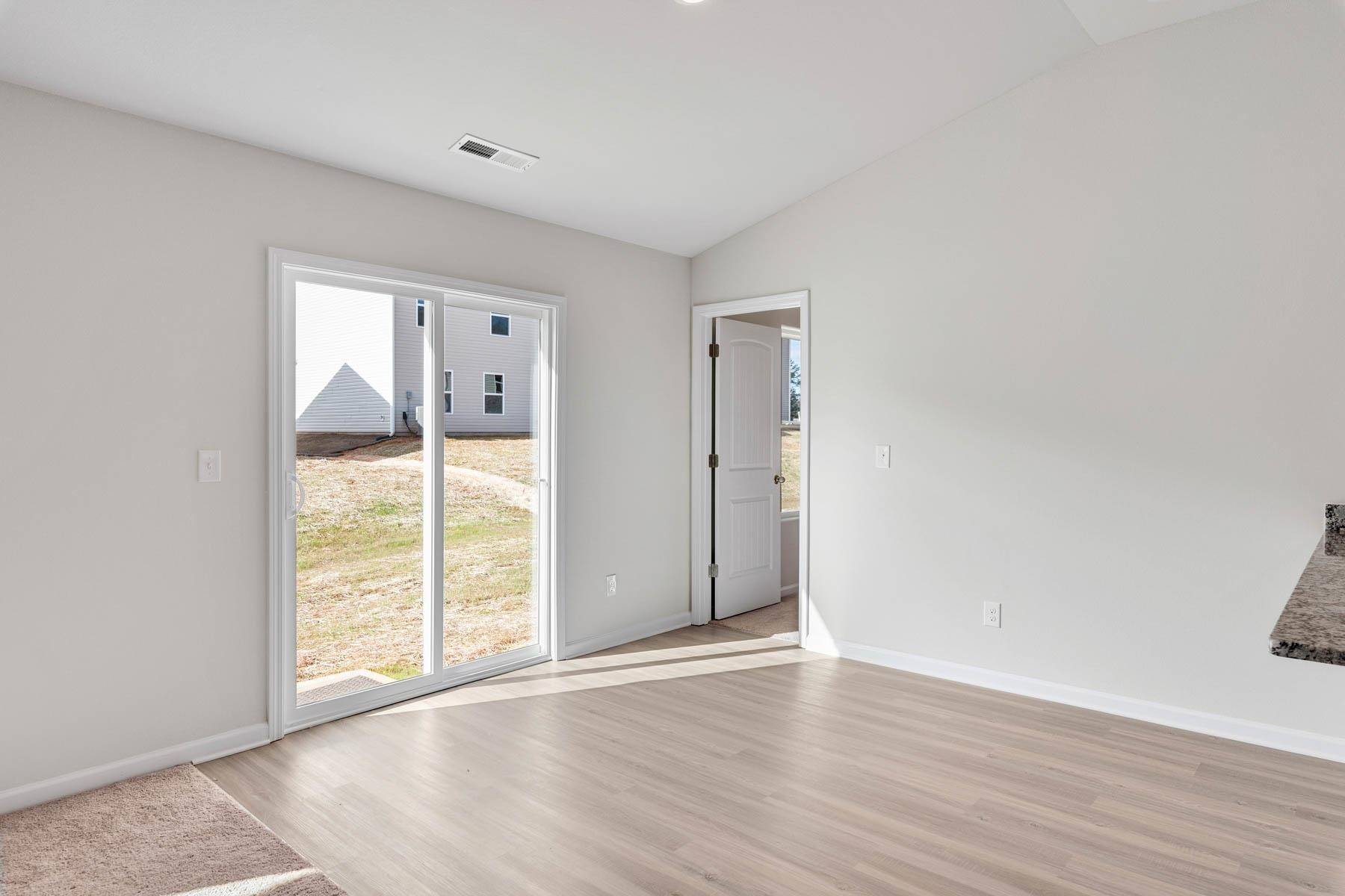 96 Crow Field Street Roxboro, NC 27574 - Photo 7 of 17 a view of an empty room with wooden floor and a window