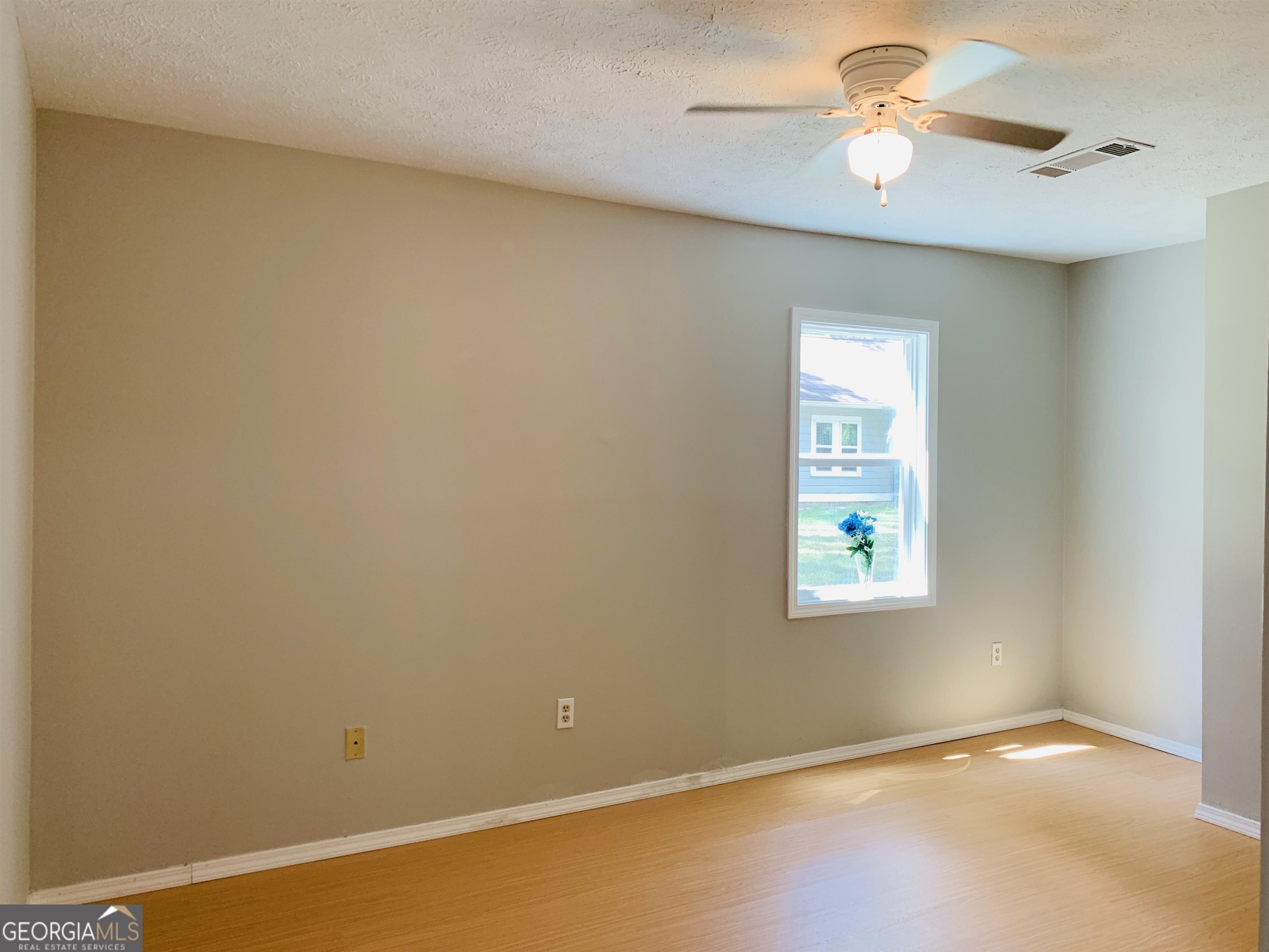 7 Burdette Place, Unit A Newnan, GA 30263 - Photo 14 of 18 an empty room with a window and a fan