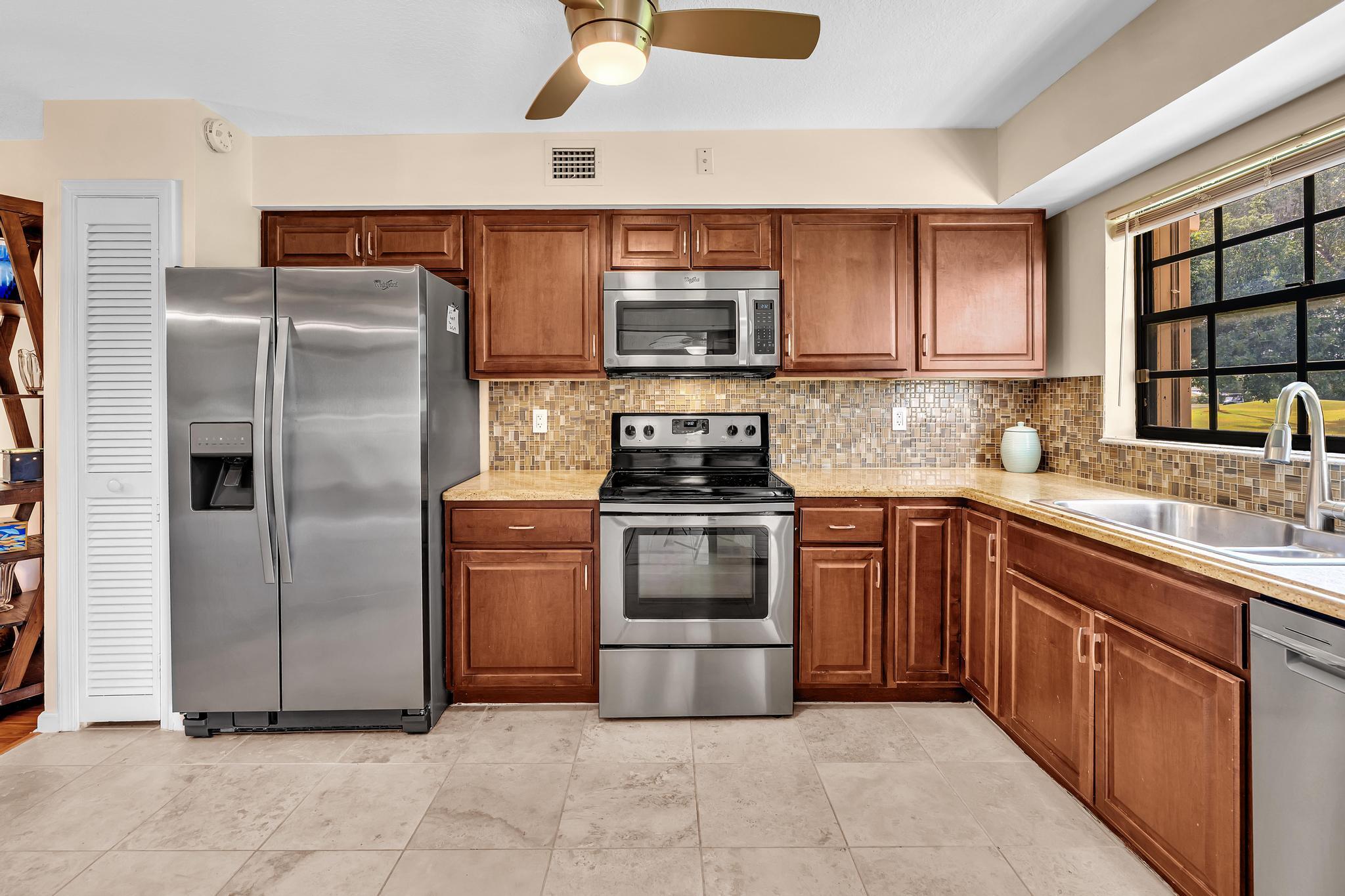 17372 Boca Club Boulevard, Unit 405 Boca Raton, FL 33487 - Photo 31 of 74 a kitchen with a refrigerator sink and cabinets