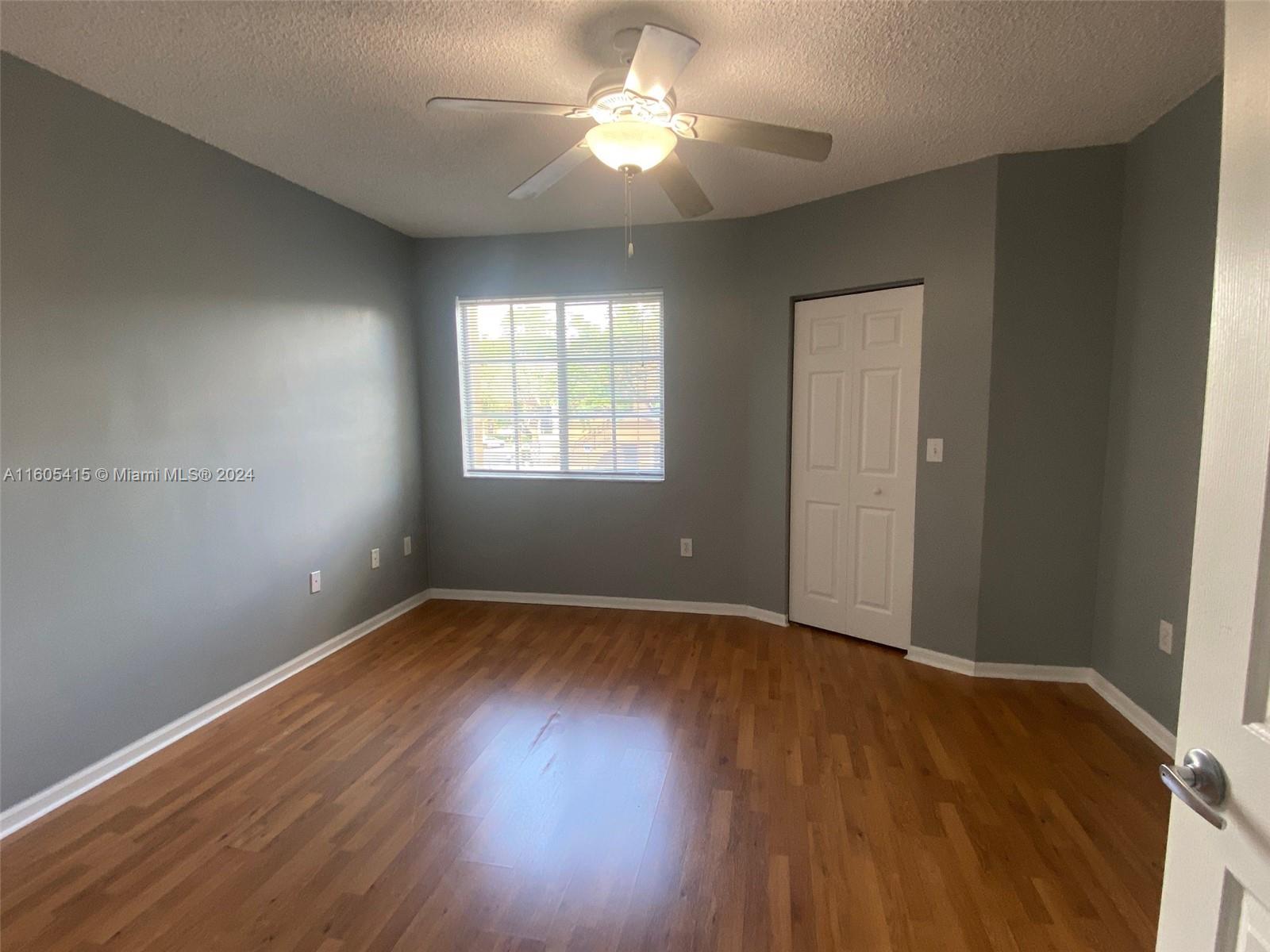 8050 North Nob Hill Road, Unit 201 Tamarac, FL 33321 - Photo 12 of 16 an empty room with wooden floor and windows