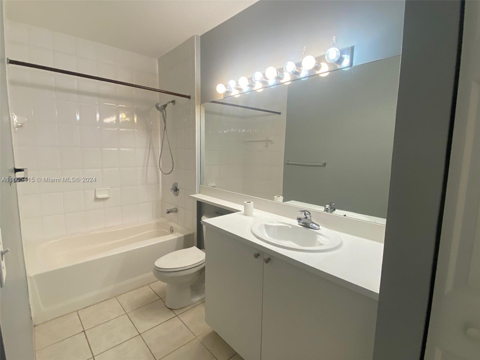 8050 North Nob Hill Road, Unit 201 Tamarac, FL 33321 - Photo 14 of 16 a bathroom with a sink a toilet a mirror and shower