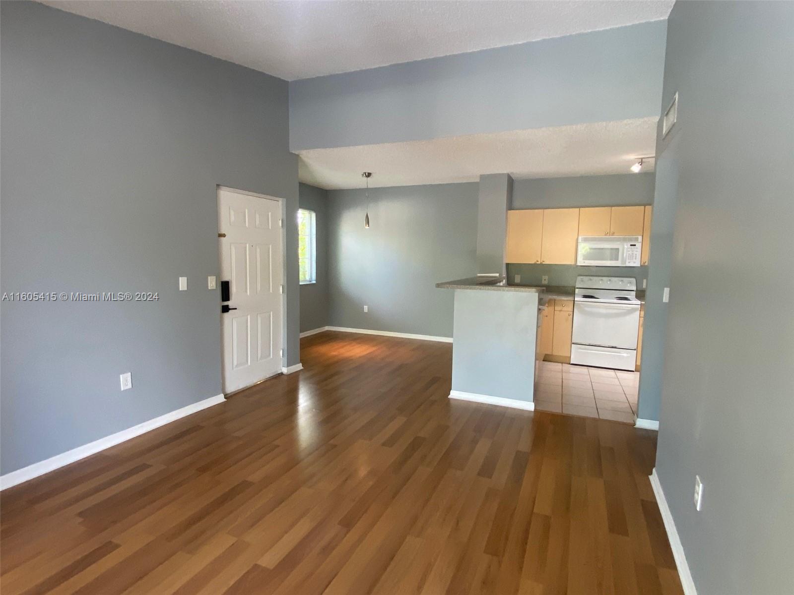 8050 North Nob Hill Road, Unit 201 Tamarac, FL 33321 - Photo 3 of 16 a kitchen with a wooden floor and cabinets