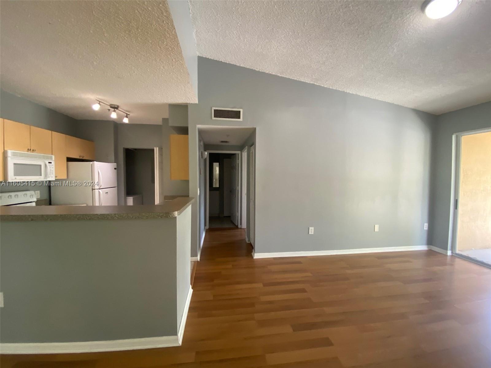 8050 North Nob Hill Road, Unit 201 Tamarac, FL 33321 - Photo 4 of 16 a view of a kitchen with furniture and wooden floor