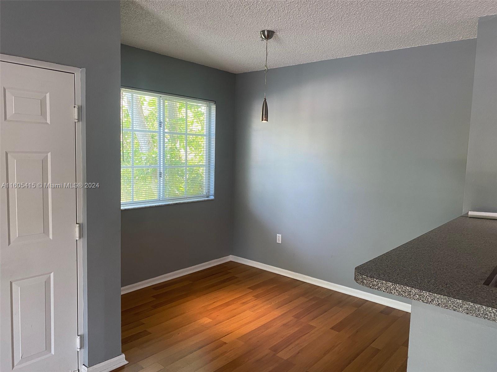 8050 North Nob Hill Road, Unit 201 Tamarac, FL 33321 - Photo 5 of 16 an empty room with wooden floor and windows