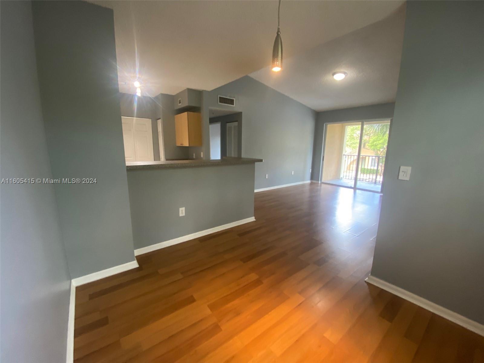 8050 North Nob Hill Road, Unit 201 Tamarac, FL 33321 - Photo 6 of 16 an empty room with wooden floor and windows