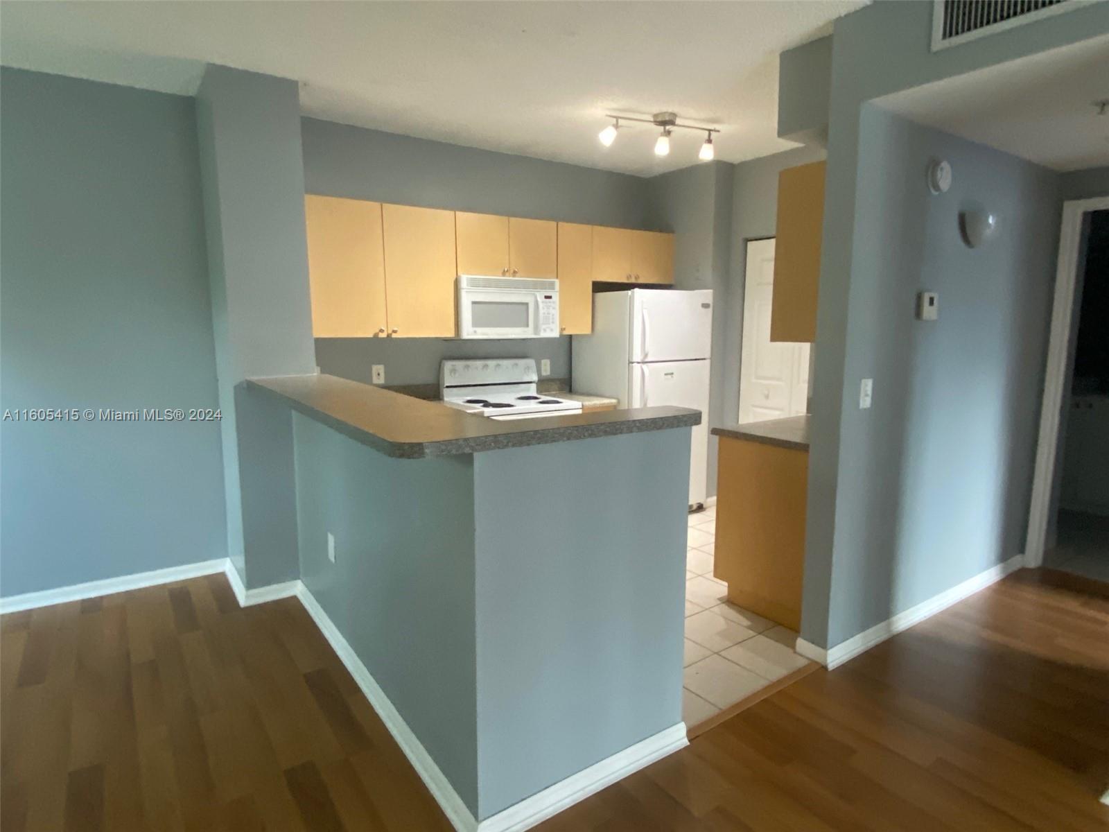 8050 North Nob Hill Road, Unit 201 Tamarac, FL 33321 - Photo 7 of 16 a kitchen with stainless steel appliances granite countertop a sink a stove and a refrigerator