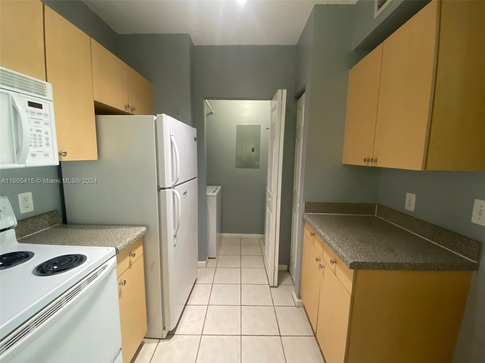 8050 North Nob Hill Road, Unit 201 Tamarac, FL 33321 - Photo 9 of 16 a kitchen with a refrigerator sink and stove