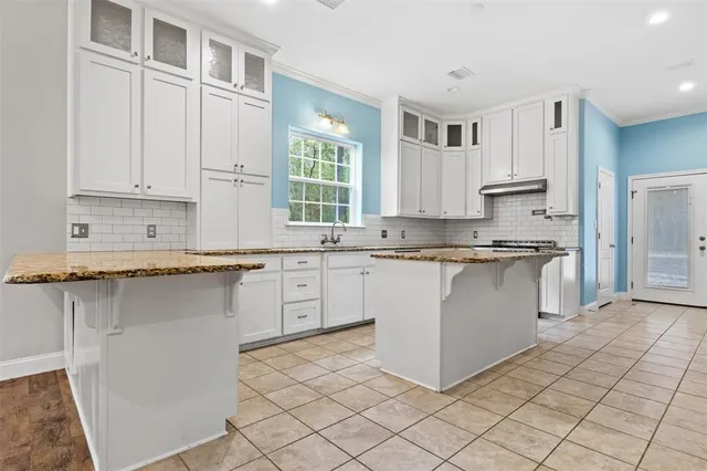 a kitchen with stainless steel appliances white cabinets and a refrigerator