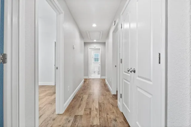 an empty room with wooden floor cabinet and windows