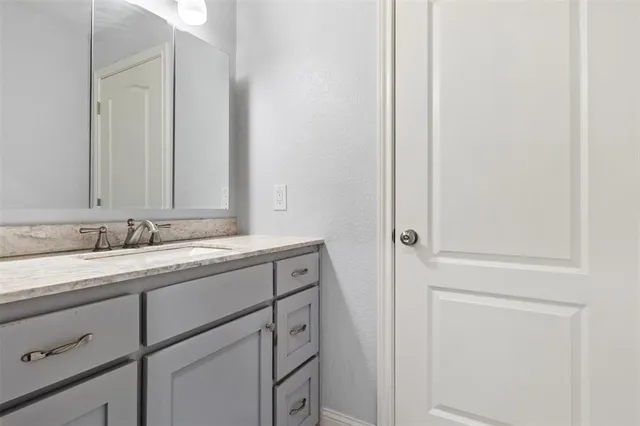 a bathroom with a granite countertop sink toilet a mirror and shower