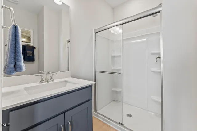 a bathroom with a sink mirror and shower