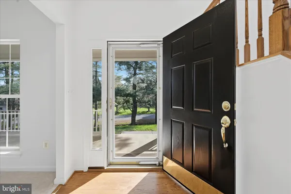 a view of a hallway with wooden floor and entryway