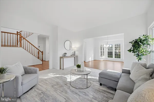 an empty room with windows and fan chandelier fan