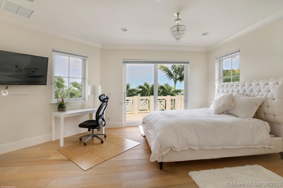 5241 Pennock Point Road Jupiter, FL 33458 - Photo 30 of 51 a bedroom with a bed a chair and a flat screen tv
