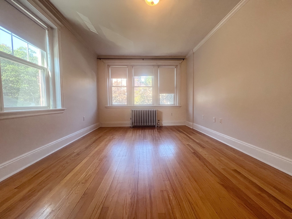 58 Selkirk Road, Unit 4 Boston, MA 02135 - Photo 5 of 5 an empty room with wooden floor and windows