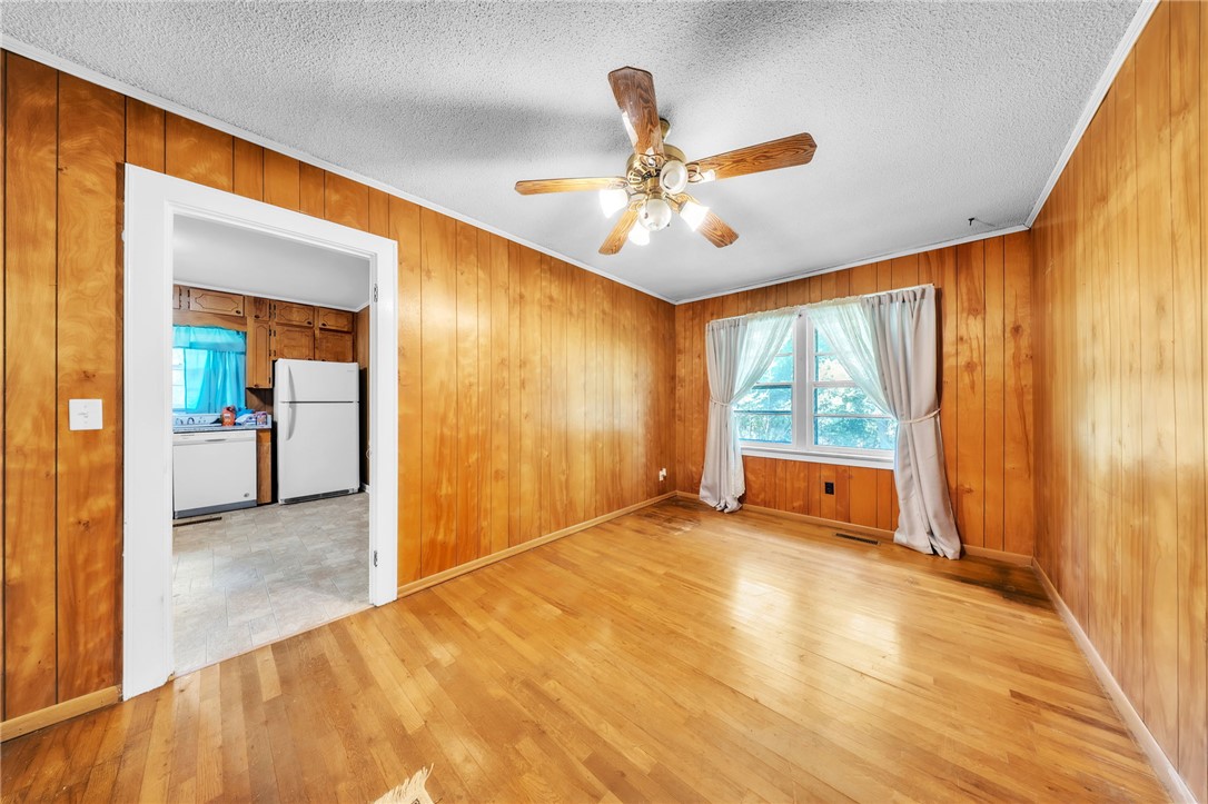 107 Burton Road Anderson, SC 29625 - Photo 10 of 33 Warm wood paneling and matching hardwood floors create a cozy, timeless interior space.