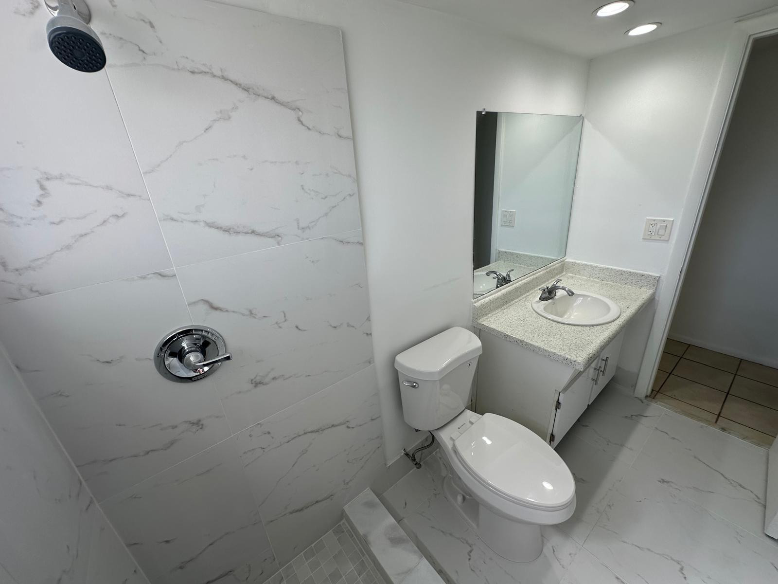 7330 Southwest 82nd Street, Unit B115 Miami, FL 33143 - Photo 11 of 19 a bathroom with a toilet sink and mirror