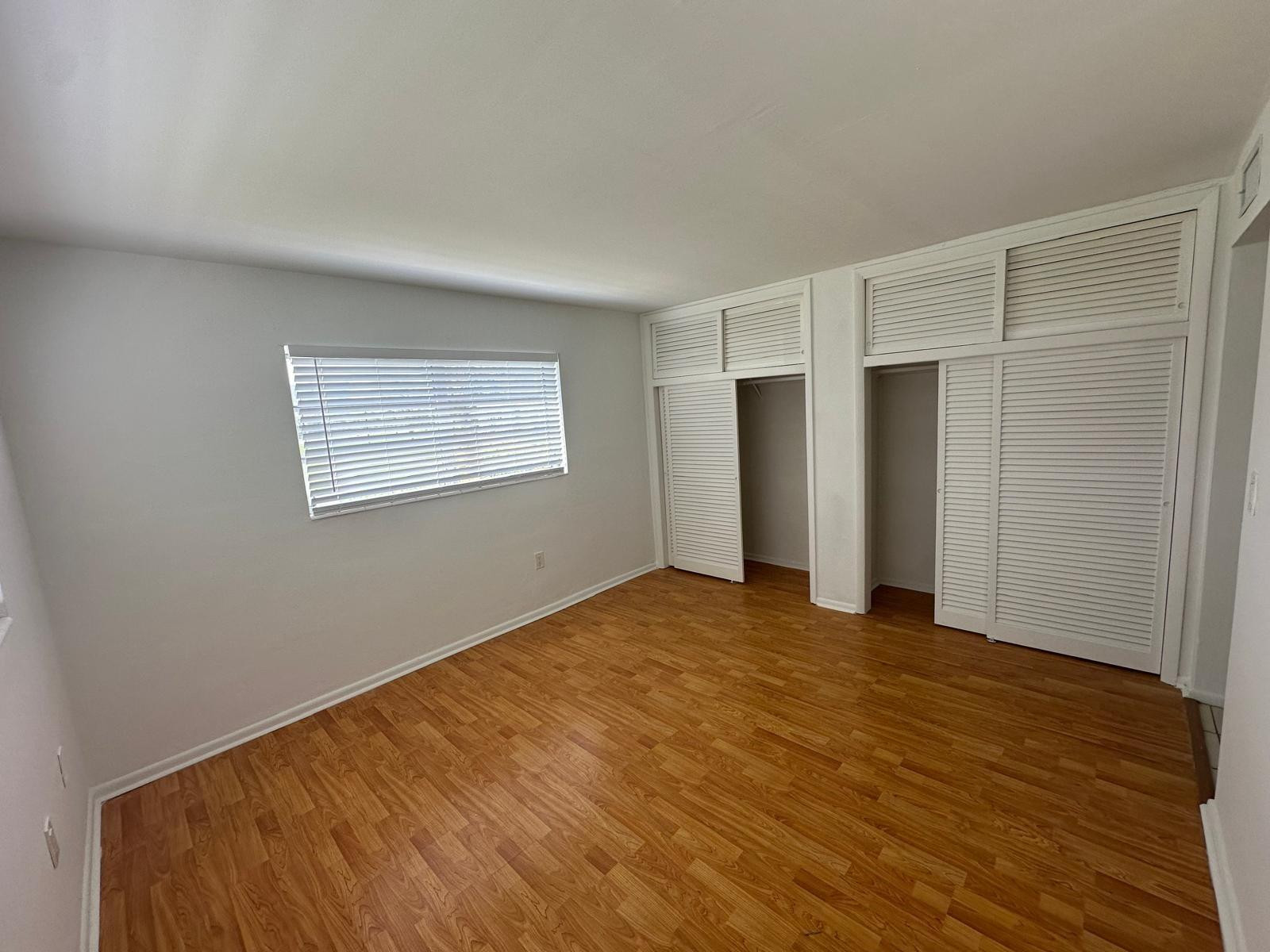 7330 Southwest 82nd Street, Unit B115 Miami, FL 33143 - Photo 18 of 19 a view of an empty room with wooden floor and a window