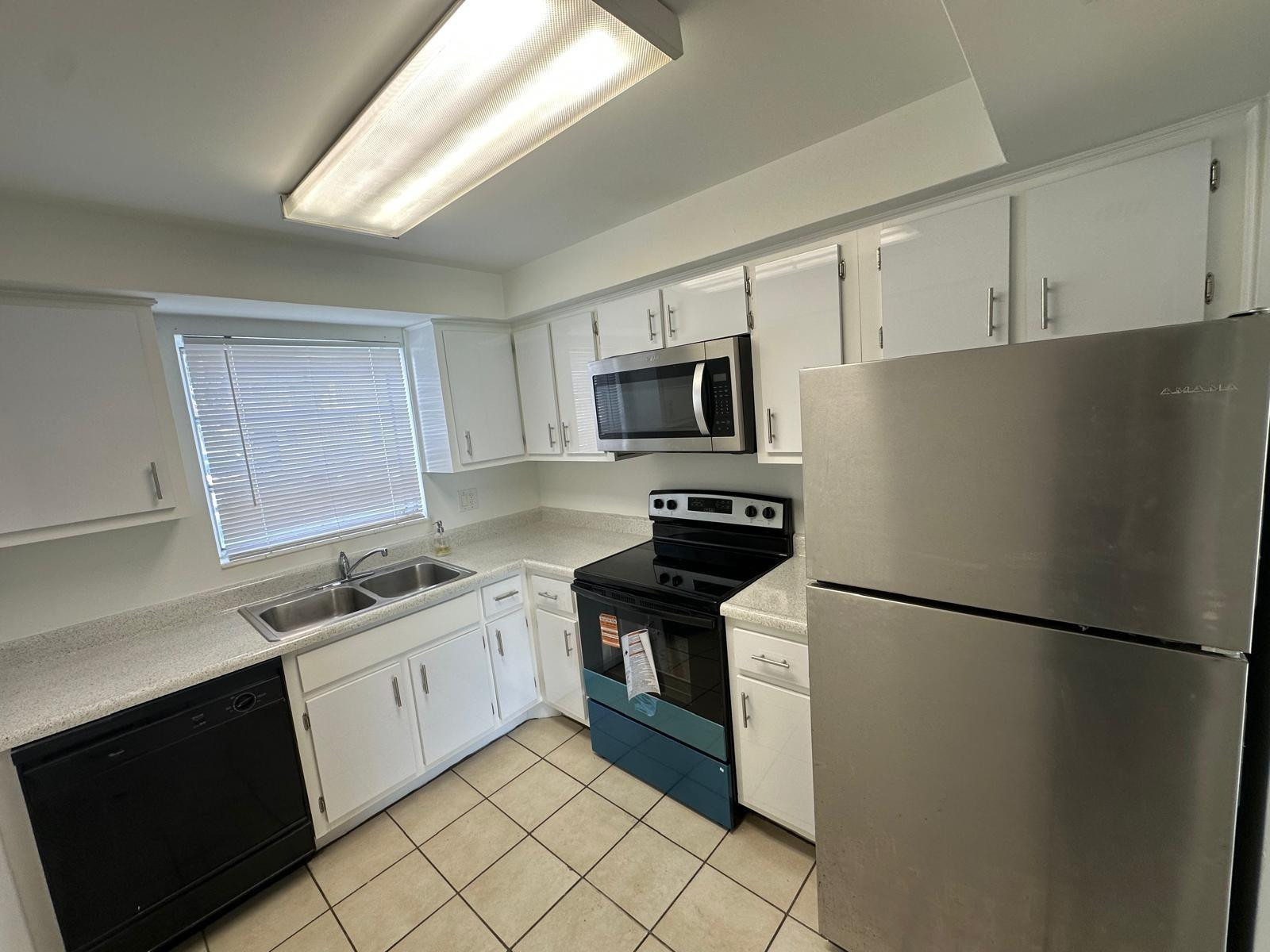 7330 Southwest 82nd Street, Unit B115 Miami, FL 33143 - Photo 5 of 19 a kitchen with a sink appliances and cabinets