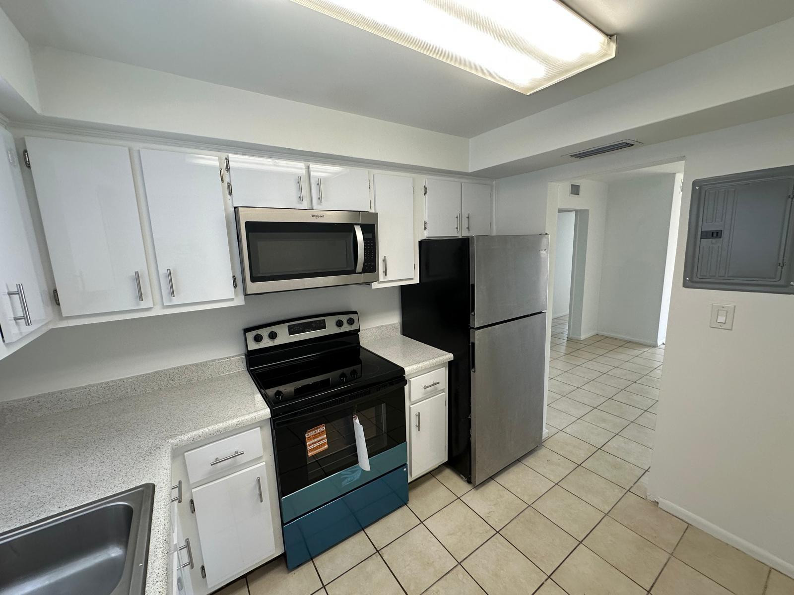 7330 Southwest 82nd Street, Unit B115 Miami, FL 33143 - Photo 6 of 19 a kitchen with a refrigerator and a stove top oven