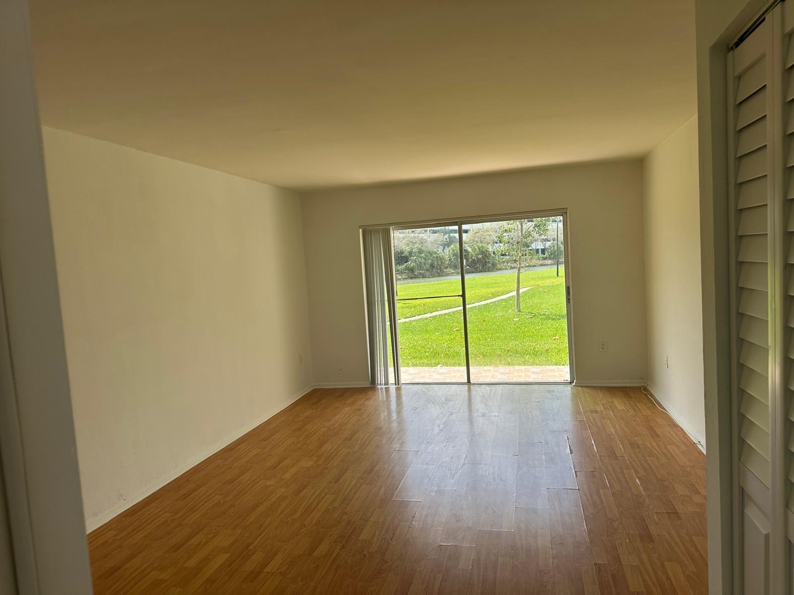 7330 Southwest 82nd Street, Unit B115 Miami, FL 33143 - Photo 7 of 19 a view of an empty room with a window and wooden floor