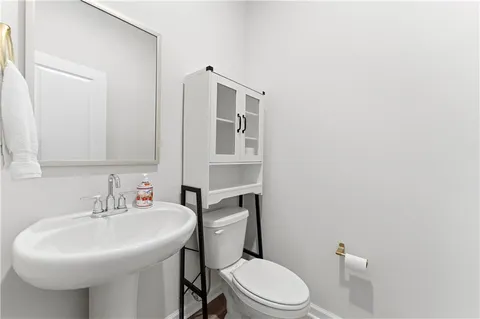 a bathroom with a sink a toilet and mirror