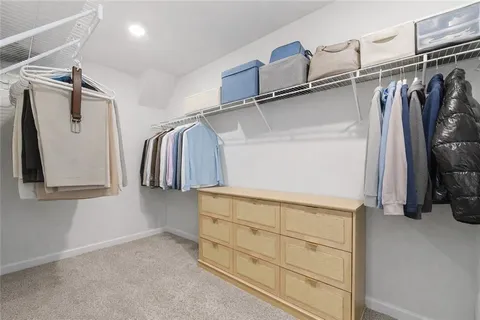 a view of walk in closet with clothes and shoes