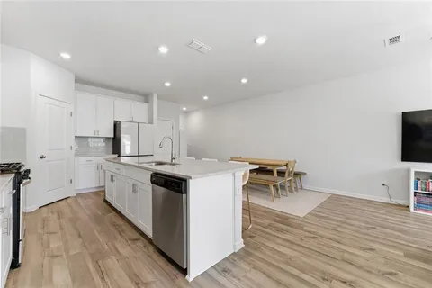 a kitchen with a sink and wooden floor
