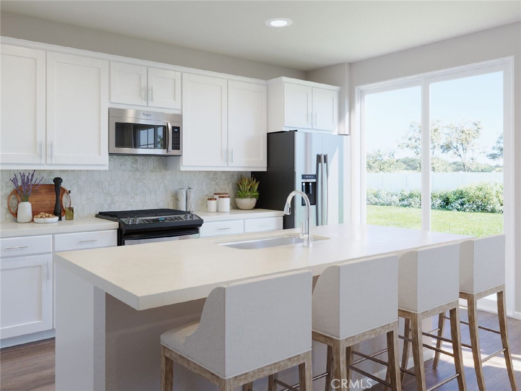 28234 Heirloom Drive Temecula, CA 92591 - Photo 2 of 17 a kitchen with stainless steel appliances a stove a sink a refrigerator a microwave and cabinets