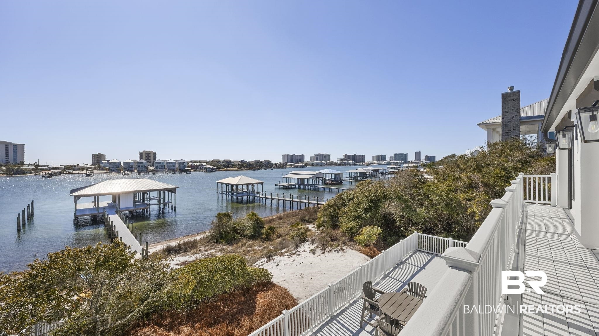 30194 River Road Orange Beach, AL 36561 - Photo 17 of 45 Primary Bedroom Balcony featuring a water view, a view of city, and a dock