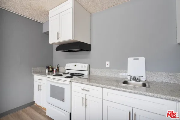 a kitchen with stainless steel appliances granite countertop a sink a stove and a microwave