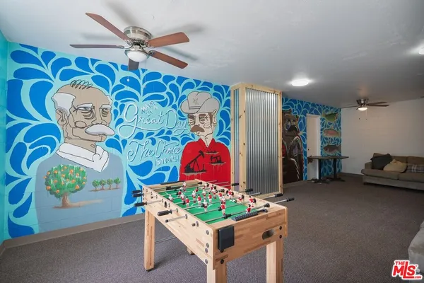 a living room with furniture and wall paintings