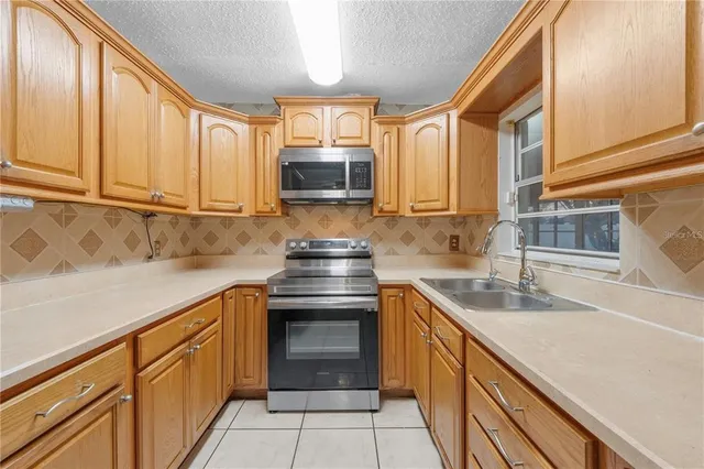 a kitchen with stainless steel appliances granite countertop a sink stove and microwave