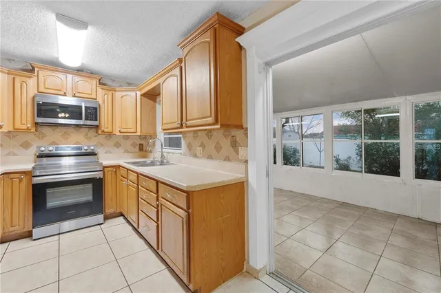 a kitchen with kitchen island granite countertop a stove top oven a sink a counter top space and cabinets