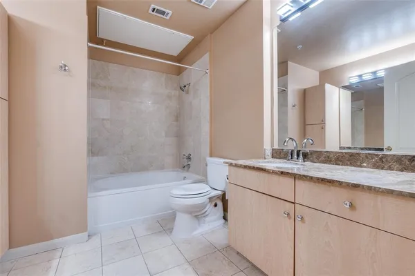a bathroom with a granite countertop sink a toilet a mirror and bathtub