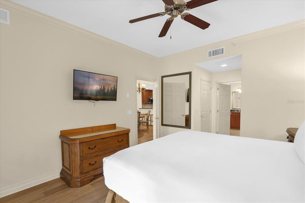 7662 Whisper Way, Unit 103 Reunion, FL 34747 - Photo 11 of 39 a bedroom with a bed and a flat screen tv